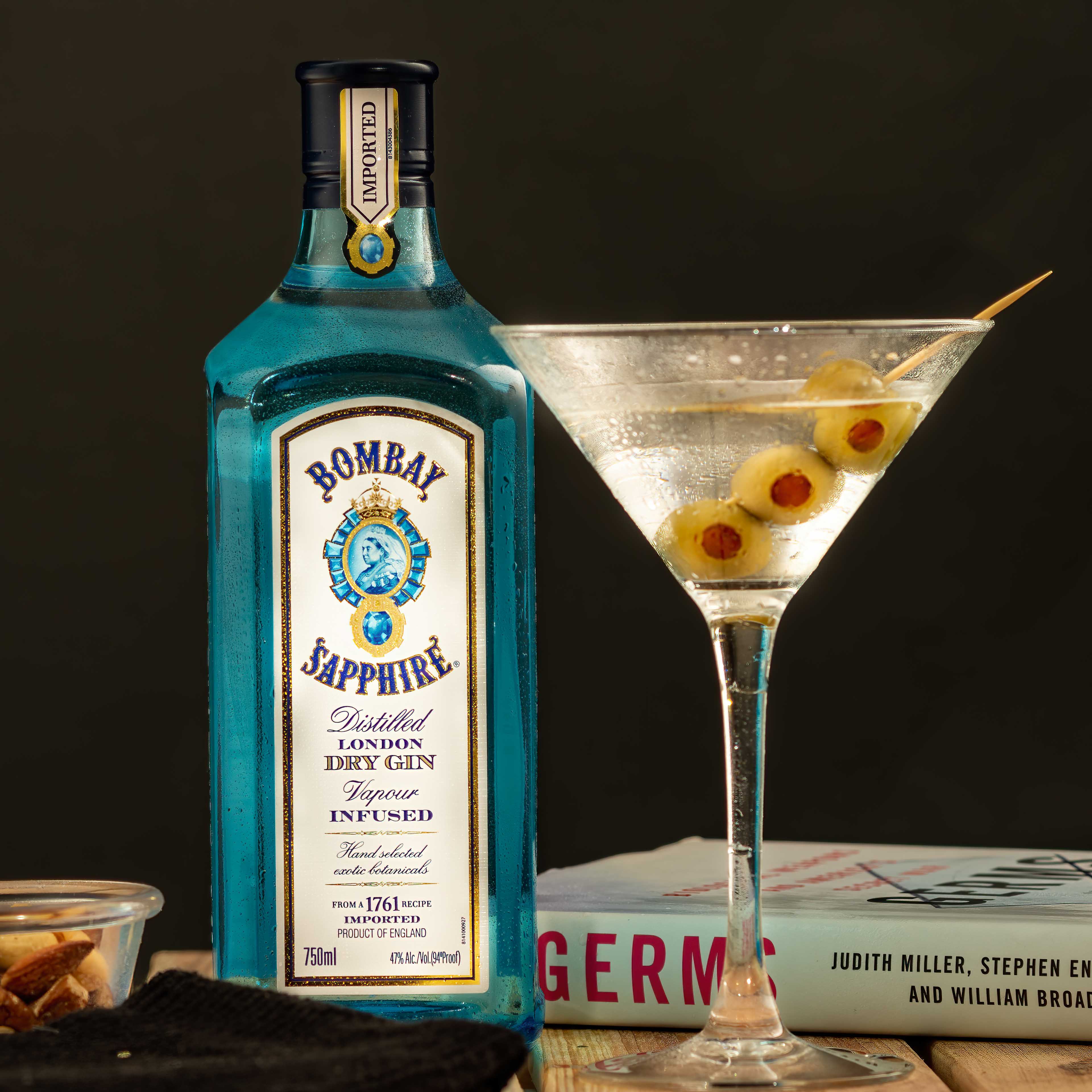 Gin martini composite - shot in studio bombay gin martini with bottle and olives and book composite shot in studio